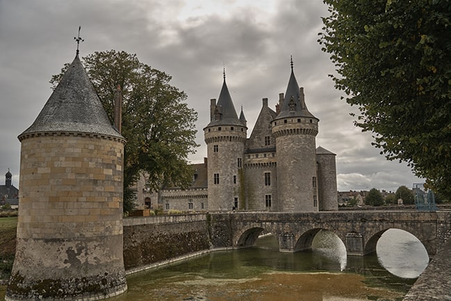 Conical-roofed towers and surrounding moat inspire tales of yore.