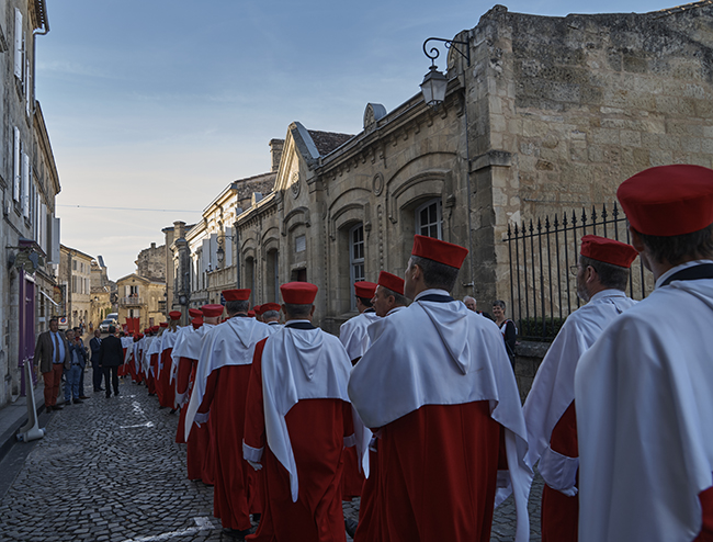 robed people parading through the street of Saint Emilion